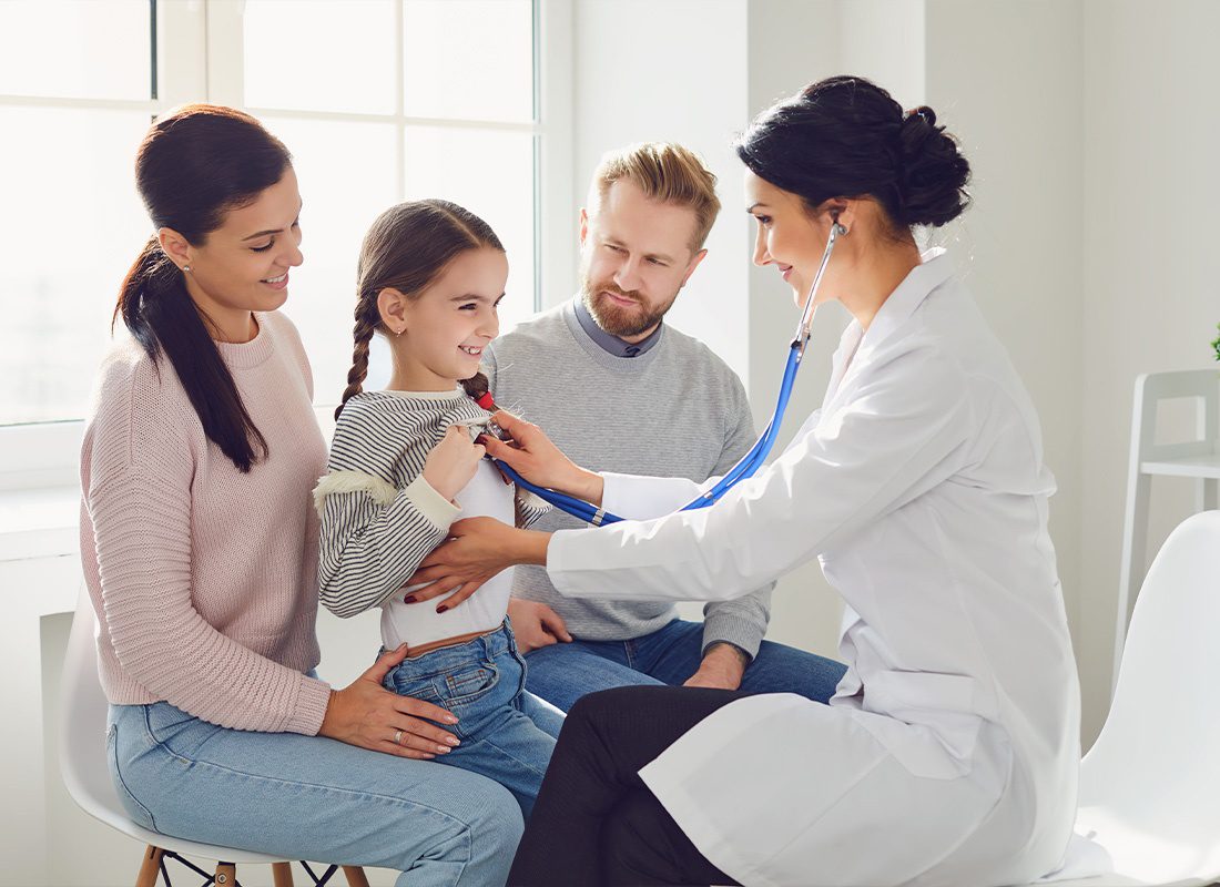 Employee Benefits - A Young Family Visiting the Doctors Office For a Routine Check Up